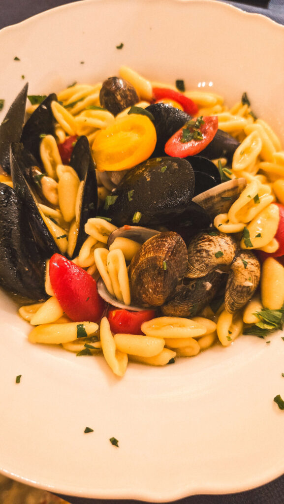 Plate of Cavatelli pasta with fresh seafood (mussels, clams) and cherry tomatoes.