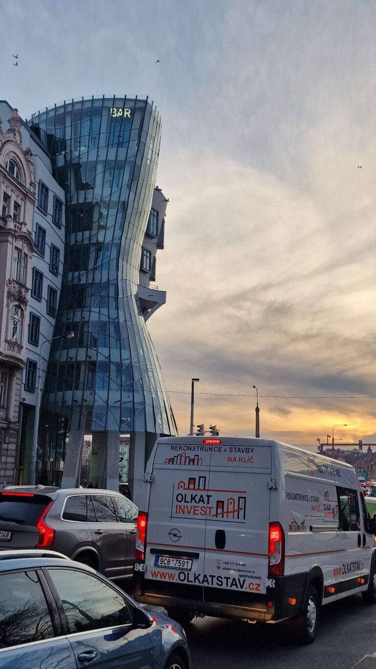 The iconic Dancing House building in Prague, with city traffic and delivery vans on the street, illustrating how to do Prague by car