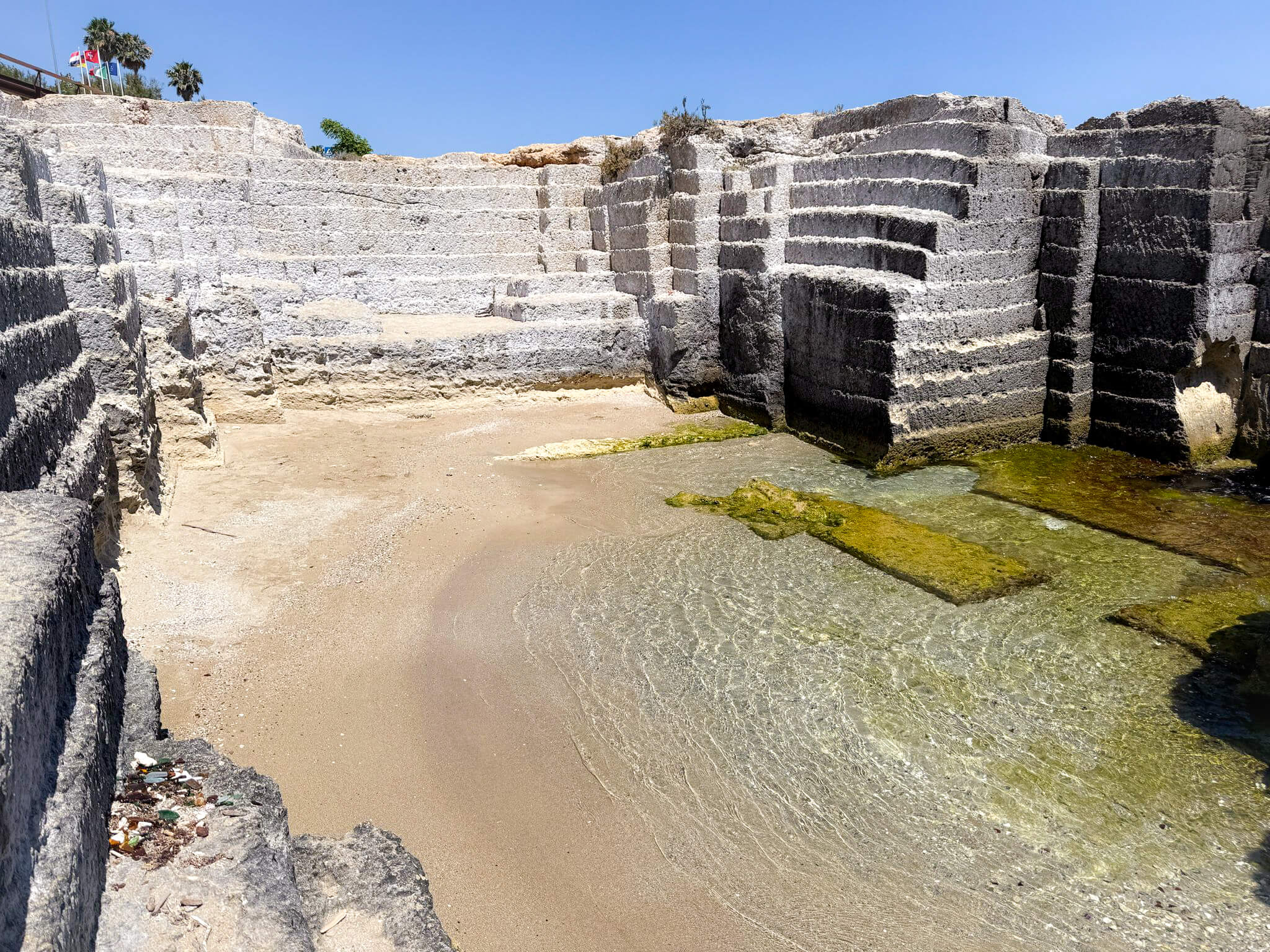Unique stepped rock formations and clear pools at Le Calette di Torre Cintola beach in Monopoli.