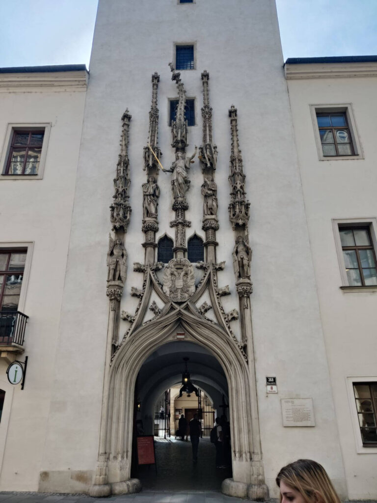 Ornate Gothic portal of the Old Town Hall in Brno with statues and an arched entrance.