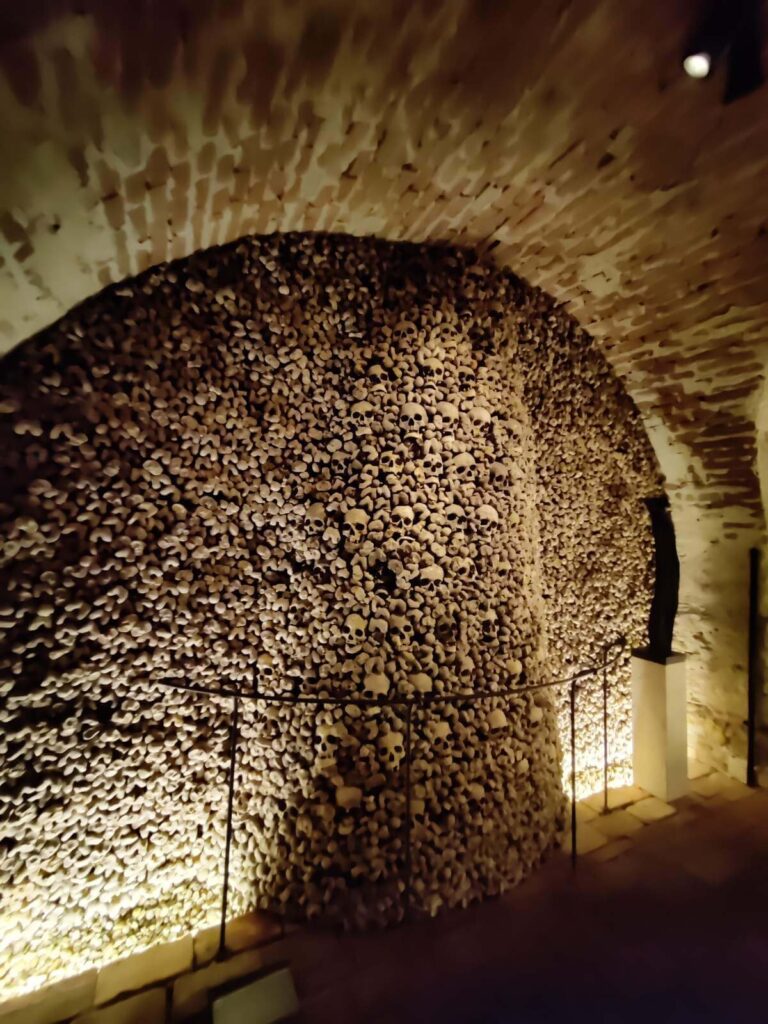 Interior view of the Brno Ossuary, showing walls densely packed with human skulls and bones.