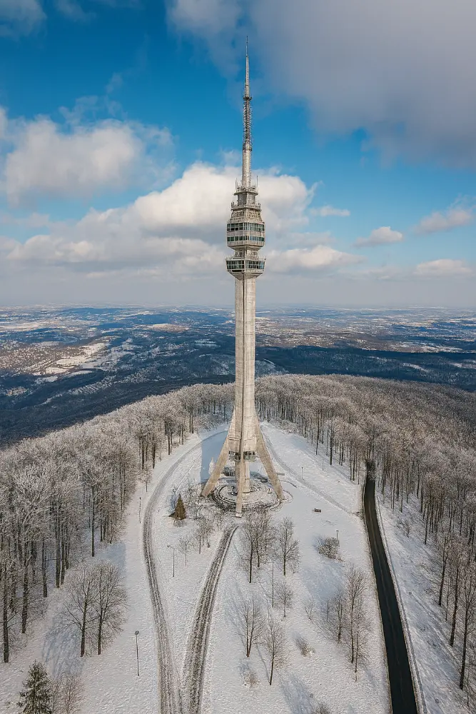 Aerial view of Avala Tower surrounded by snowy forest near Belgrade in winter
