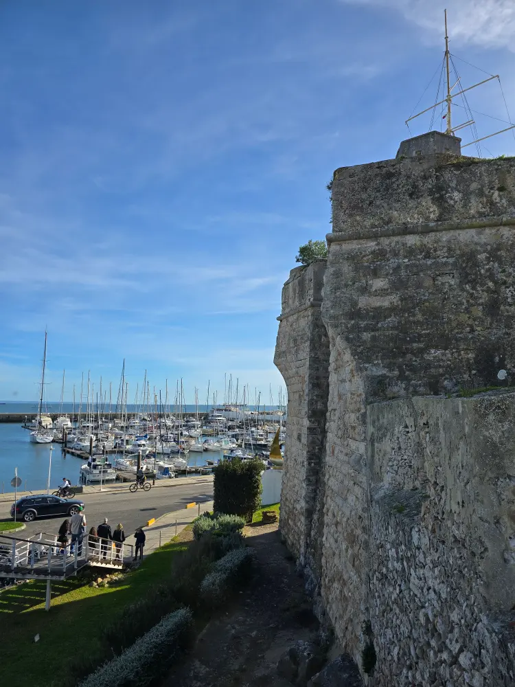 Old fortress wall overlooking the marina and sailboats in Cascais, Portugal