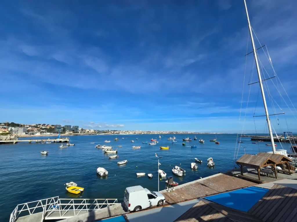 Boats floating in the blue waters of Estoril Marina under a clear sky