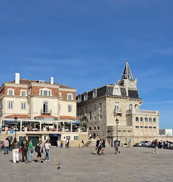 People walking across Praça 5 de Outubro in Cascais old town on a sunny day