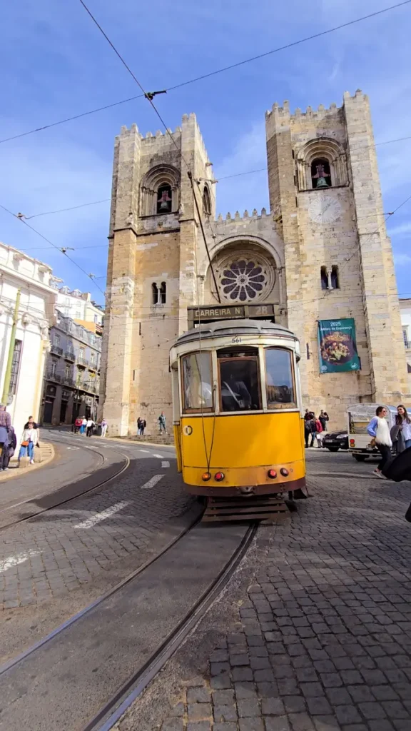 Yellow Tram 28 passing by Lisbon Cathedral – one of the most popular things to do in Lisbon for visitors exploring the old city.