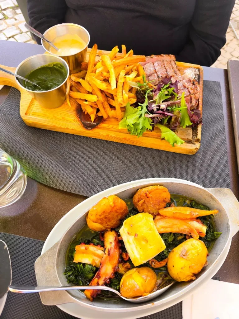 Portuguese meal with grilled octopus, potatoes, steak, and fries served at a Cascais restaurant
