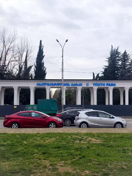 The white pillar entrance of Youth Park in Kutaisi, the primary landmark for finding the City Bus stop to Tbilisi on Chavchavadze Avenue.