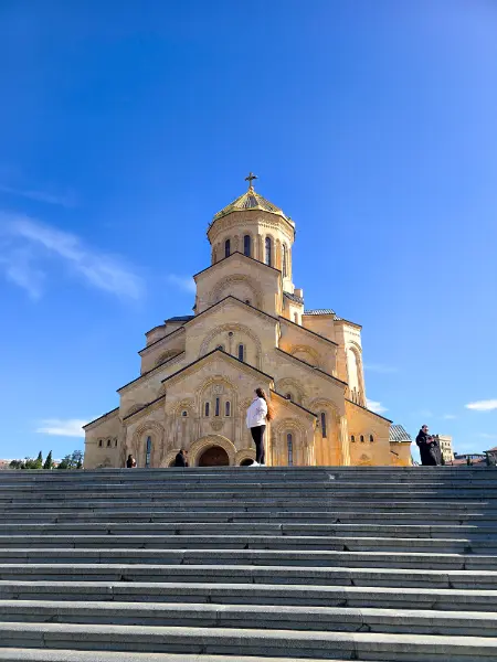 Tbilisi travel guide photo of the massive Sameba Holy Trinity Cathedral under a blue sky.