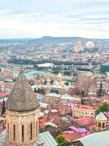 Tbilisi travel guide panoramic view of the Old Town rooftops from Narikala Fortress.